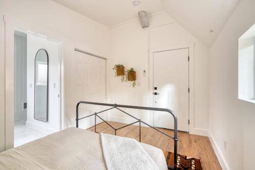 a bedroom with white walls and a bed in a room at Mt Hood Log Cabin! Fresh Remodel with Airstream 2 in Mount Hood Village