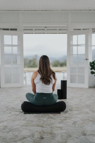 a woman sitting in a yoga pose on the floor at The Wellness Farm Broke in Broke