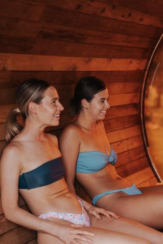 two women in bikinis sitting in front of a mirror at The Wellness Farm Broke in Broke