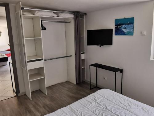 a bedroom with a bed and a tv on a wall at Maison calme avec clim, WIFI, jardin et vue sur le Lay - FR-1-194-274 in LʼAiguillon-sur-Mer