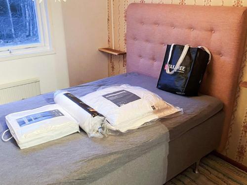 a bed with a bag and books on it at Countryside retreat for 4 guests in Skånes Fagerhult