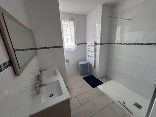 une salle de bain blanche avec une douche et un lavabo dans l'établissement Maison rénovée 3 chambres près de l'océan avec jardin fermé et WiFi - FR-1-194-290, à La Faute-sur-Mer