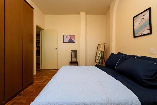 a bedroom with a large bed with blue sheets at Santa Teresa Junto à Natureza in Rio de Janeiro