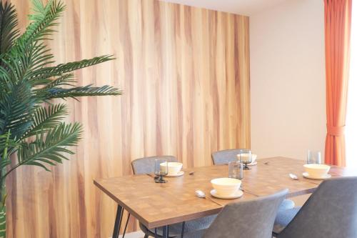 a wooden table and chairs in a room with a plant at Z LAND Enoshima in Fujisawa
