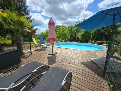 une terrasse avec une piscine, un parasol et des chaises dans l'établissement Appartement cosy avec terrasse et piscine dans le Périgord Noir - FR-1-616-473, à Saint-Chamassy