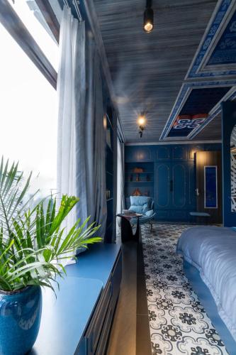 a bedroom with blue walls and a bed and plants at Color House Sa Pa - Free BBQ in Sapa