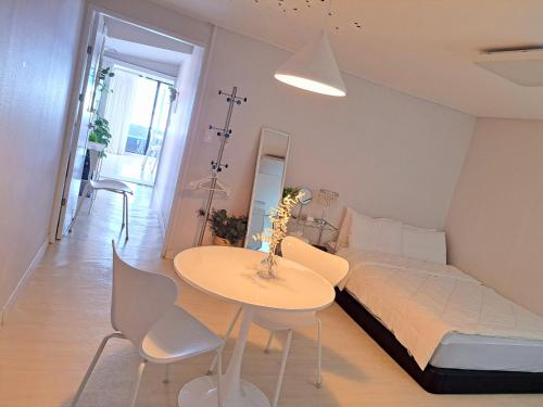 a bedroom with a bed and a table and chairs at Narae House in Busan
