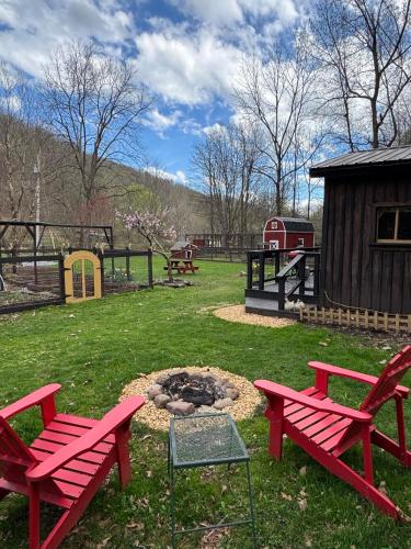 two red picnic tables and a fire pit in a park at The Renovated Barn at Seneca Rocks in Seneca Rocks