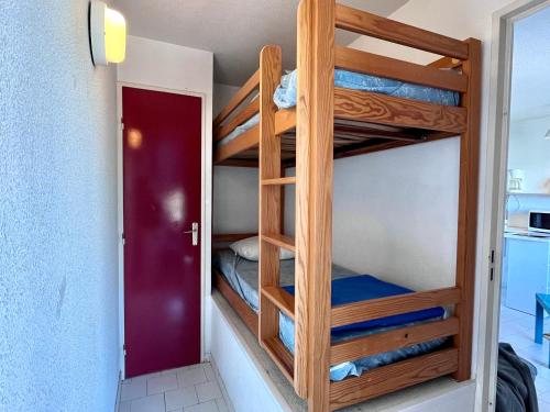 Cette chambre dispose de lits superposés et d'une porte rouge. dans l'établissement Studio cabine à 300m de la plage avec loggia vitrée - FR-1-338-428, à Sète