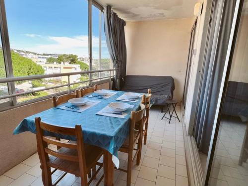 une salle à manger avec une table et des chaises et un balcon dans l'établissement Studio cabine à 300m de la plage avec loggia vitrée - FR-1-338-428, à Sète
