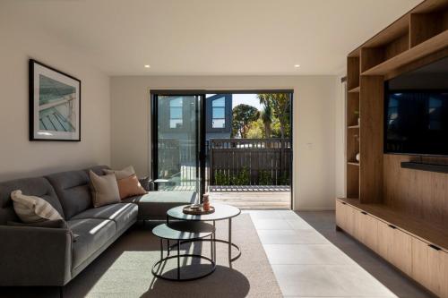 a living room with a couch and a tv at New Three Bedroom Townhouse - Walk to the CBD! in Christchurch