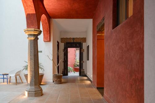 a hallway with red walls and a pillar in a room at Solazul Experiencia & Estancia in Puebla