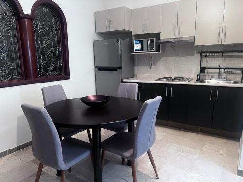 a kitchen with a black table and chairs in a kitchen at Tu hogar en Zapotlanejo in Zapotlanejo