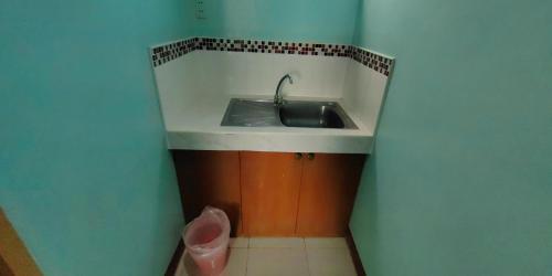 a kitchen with a sink and a trash can at Dads Bayview Pension in Puerto Princesa City