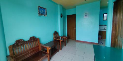 a room with two benches and a blue wall at Dads Bayview Pension in Puerto Princesa City