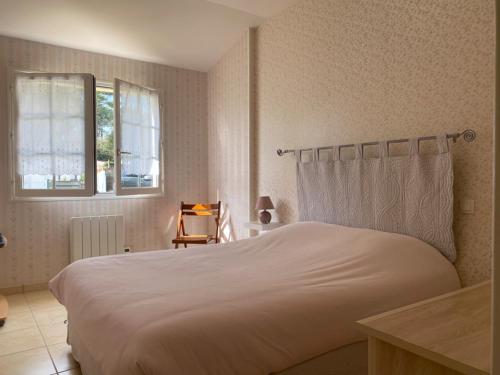 une chambre avec un grand lit blanc et une fenêtre dans l'établissement Maison bord de mer calme à Jard-sur-Mer avec grand jardin clos - FR-1-336-162, à Jard-sur-Mer