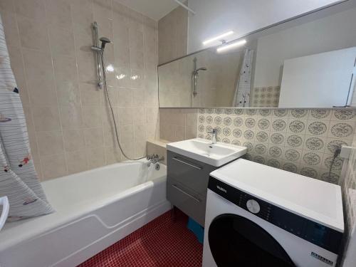 La salle de bains est pourvue d'un lavabo, d'une baignoire, de toilettes et d'une baignoire. dans l'établissement Appartement T3 centre Arcachon avec vue mer, WIFI, parking sécurisé - FR-1-374-237, à Arcachon