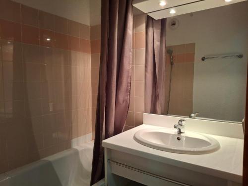 une salle de bain avec un lavabo, une baignoire et un miroir dans l'établissement Location saisonnière à Saint-François-Longchamp pour 8 personnes - FR-1-807-132, à Saint-François-Longchamp