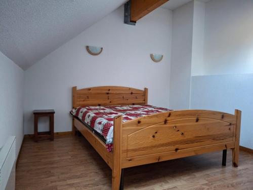 une chambre avec un lit en bois dans une pièce dans l'établissement T2 confort 4 pers, balcon ensoleillé, proche pistes - FR-1-807-134, à Saint-François-Longchamp
