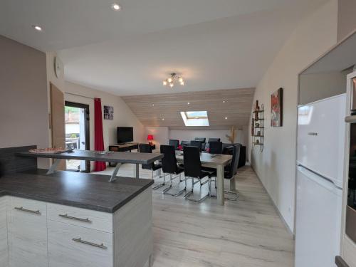 une cuisine et une salle à manger avec une table et des chaises dans l'établissement Gîte lumineux pour 2 personnes dans les Hautes-Vosges - FR-1-589-811, à Le Thillot