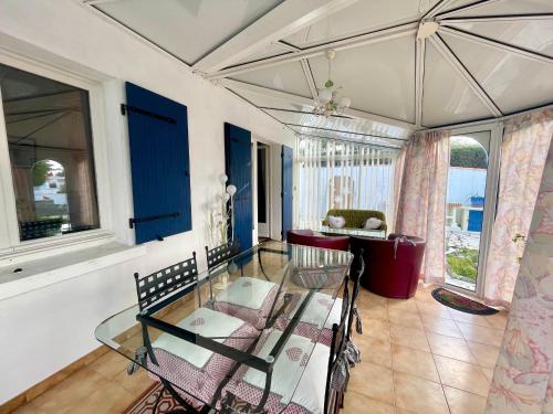 une salle à manger avec une table et des chaises en verre dans l'établissement Maison calme à 400m de la mer, véranda, jardin - FR-1-231-337, à Bretignolles-sur-Mer