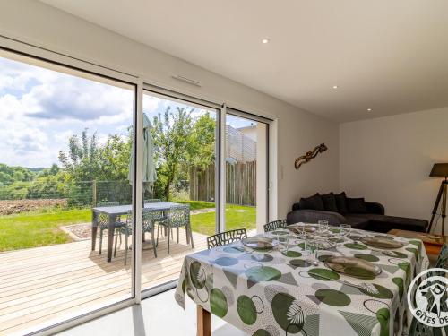une salle à manger avec une table et un balcon dans l'établissement Gîte moderne avec jardin clos et animaux admis près de Nantes et Angers - FR-1-622-108, à Saint-Christophe-la-Couperie