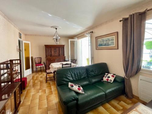 un salon avec un canapé vert et une table dans l'établissement Maison calme à 400m de la mer, véranda, jardin - FR-1-231-337, à Bretignolles-sur-Mer