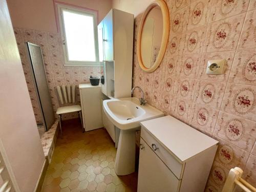 une salle de bain avec un lavabo et un miroir dans l'établissement Maison calme à 400m de la mer, véranda, jardin - FR-1-231-337, à Bretignolles-sur-Mer