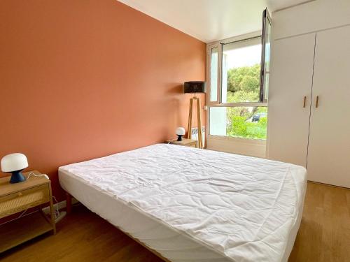 une chambre avec un lit blanc et une fenêtre dans l'établissement Maison moderne proche plage avec patio et parking privatif - FR-1-748-32, à Canet