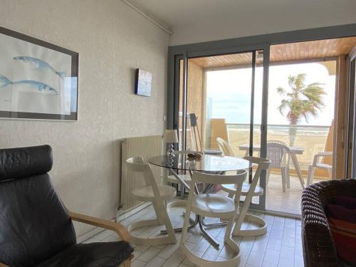 un salon avec une table et des chaises et un balcon dans l'établissement Deux-pièces face mer pour 4 pers à Canet-Plage - FR-1-750-99, à Canet