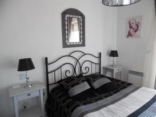 une chambre avec un lit noir et blanc et un miroir dans l'établissement Charmant 2 Pièces Proche Plage avec Parking Privé - FR-1-750-102, à Canet