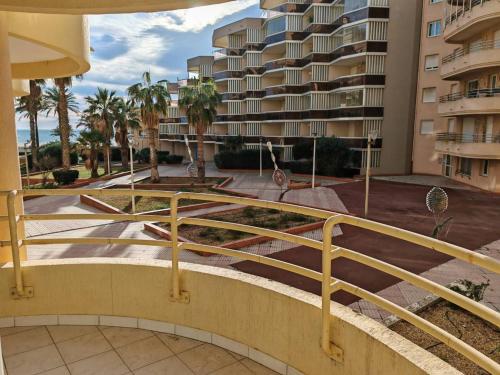 un escalier en face d'un bâtiment avec des palmiers dans l'établissement Appartement 3 pièces face plage - 6 pers, clim, parking - FR-1-750-106, à Canet