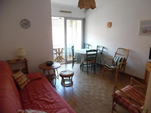 - un salon avec un canapé rouge, une table et des chaises dans l'établissement Deux-Pièces Front de Mer pour 4 Pers à Canet-Plage - FR-1-750-107, à Canet