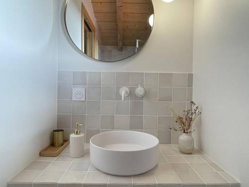 La salle de bains est pourvue d'une grande baignoire blanche et d'un miroir. dans l'établissement Luxe Triplex bord de mer à Hossegor - FR-1-791-40, à Soorts-Hossegor