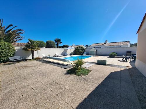 une cour avec une piscine dans une maison dans l'établissement Maison charmante pour 6 personnes, résidence calme avec piscine privée - FR-1-323-578, à Saint-Jean-de-Monts