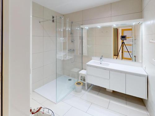 une salle de bain blanche avec un lavabo et une douche dans l'établissement Spacieux 2P rénové avec climatisation, terrasse et balcon face mer - FR-1-196-381, à Menton