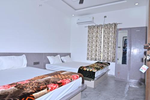 une chambre d'hôtel avec deux lits et une fenêtre dans l'établissement Hotel Rudraksha Restaurant And Resort, à Khātu