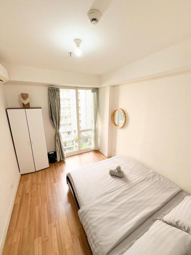 a bedroom with a large white bed and a window at Oslandmark Residence in Bandung