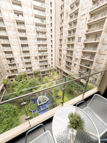 a balcony with a table and chairs and tall buildings at Oslandmark Residence in Bandung