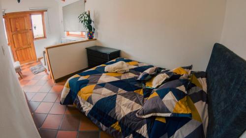 1 dormitorio con 1 cama con colcha colorida en Cabaña Deluxe en Villa de Leyva, VillaClarita, en Villa de Leyva
