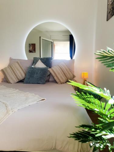 - une chambre avec un grand lit blanc et un grand miroir dans l'établissement Carnac, à Montigny-le-Bretonneux