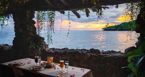 a table with a view of the ocean at sunset at Savasi Island Resort in Savusavu