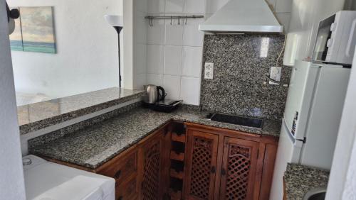 Una pequeña cocina con fregadero y refrigerador. en Dominión Park Apartamento, en Cala del Moral