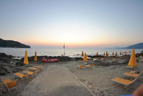 a group of chairs and umbrellas on a beach at Grand Hotel San Pietro in Palinuro