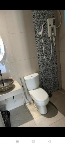 a bathroom with a toilet and a shower and a sink at Cabana Chalet Cherating in Cherating