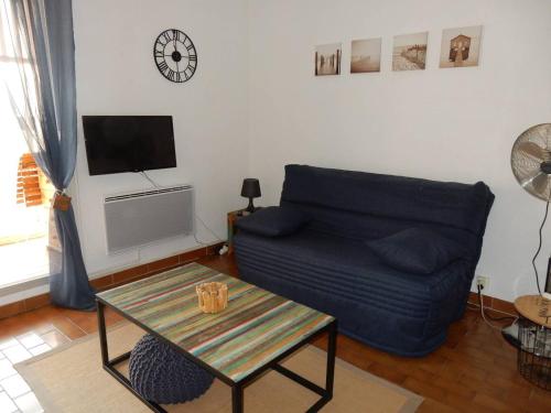 un salon avec un canapé et une table dans l'établissement Studio Cabine 2* avec Parking, Proche Plage - FR-1-750-111, à Canet