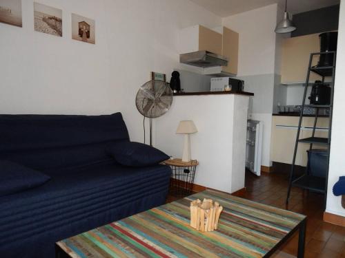 un salon avec un canapé bleu et une table dans l'établissement Studio Cabine 2* avec Parking, Proche Plage - FR-1-750-111, à Canet