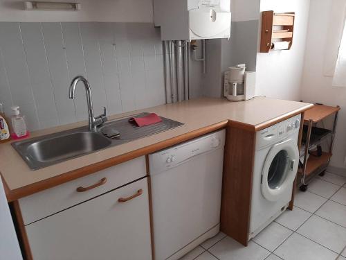 une cuisine avec un évier et une machine à laver dans l'établissement Deux-pièces en bord de mer pour 4 personnes - FR-1-750-114, à Canet
