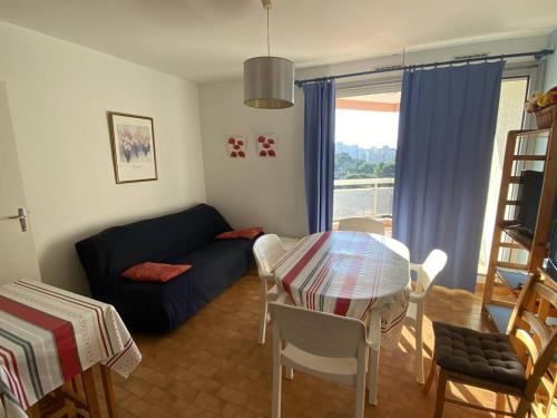 un salon avec un canapé bleu et une table dans l'établissement Charmant deux-pièces sud avec terrasse vue mer à Canet-Plage - FR-1-750-113, à Canet