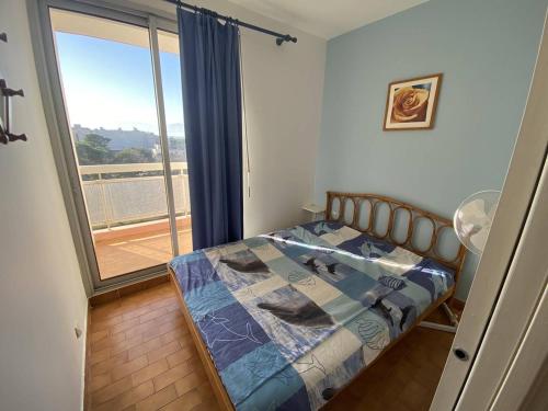 une chambre avec un lit et une grande fenêtre dans l'établissement Charmant deux-pièces sud avec terrasse vue mer à Canet-Plage - FR-1-750-113, à Canet